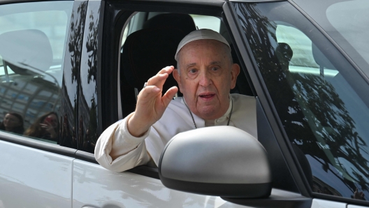 Pope Francis waves as he leaves the Gemelli hospital on April 1, 2023 in Rome, after being discharged following treatment for bronchitis. - The 86-year-old pontiff was admitted to Gemelli hospital on March 29 after suffering from breathing difficulties. (Photo by Filippo MONTEFORTE / AFP)