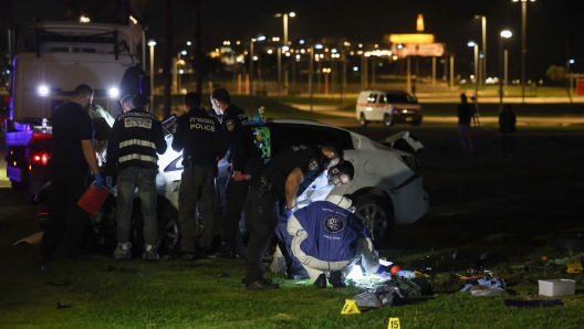 Israeli police inspect the car used in an attack in Tel Aviv on April 7, 2023. - One man was killed and four people were wounded in an attack in central Tel Aviv, Israeli rescue services said, updating a previous casualty toll of two injured. (Photo by AHMAD GHARABLI / AFP)