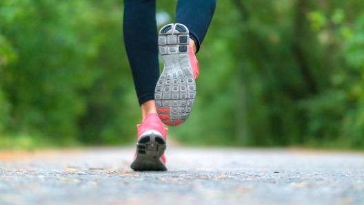 Running woman in the forest. Close-up of sneakers. Helathy lifestyle concept.