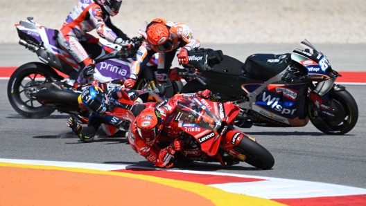 Honda Spanish rider Marc Marquez (C TOP) crashes with Aprilia Portuguese rider Miguel Oliveira (C BOTTOM) as Ducati Italian rider Francesco Bagnaia (R) rides past during the MotoGP race of the Portuguese Grand Prix at the Algarve International Circuit in Portimao, on March 26, 2023. (Photo by PATRICIA DE MELO MOREIRA / AFP)