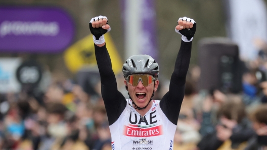 epa10555568 Slovenia's Tadej Pogacar of UAE Team Emirates celebrates as he crosses the finish line to win the Ronde van Vlaanderen (Tour of Flanders) cycling race from Bruges to Oudenaarde, in Oudenaarde, Belgium, 02 April 2023.  EPA/OLIVIER MATTHYS