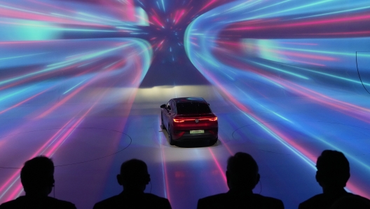 Attendees watch a presentation of Volkswagen's latest vehicles on the eve of the Auto Shanghai 2023 show in Shanghai, China, Monday, April 17, 2023. Global and Chinese automakers plan to unveil more than a dozen new electric SUVs, sedans and muscle cars this week at the Shanghai auto show, their first full-scale sales event in four years in a market that has become a workshop for developing electrics, self-driving cars and other technology. (AP Photo/Ng Han Guan)