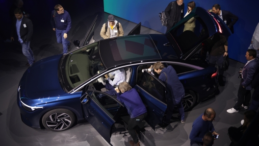 BERLIN, GERMANY - APRIL 17: Members of the media crowd around the new Volkswagen ID.7 electric sedan at its official debut event on April 17, 2023 in Berlin, Germany. German carmaker Volkswagen is expanding its lineup of electric cars as it transitions away from the combustion engine. (Photo by Sean Gallup/Getty Images)