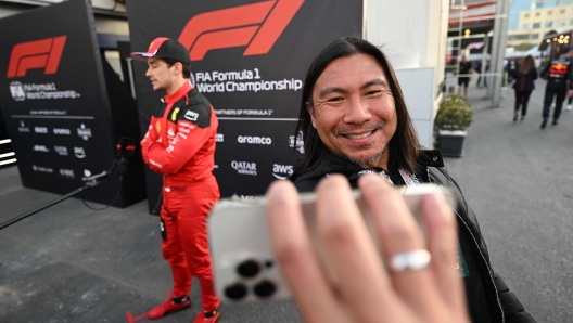 A man takes a selfie picture with his smartphone as Ferrari's Monegasque driver Charles Leclerc talks to the media after the qualifying session for the Formula One Azerbaijan Grand Prix at the Baku City Circuit in Baku on April 28, 2023. (Photo by NATALIA KOLESNIKOVA / AFP)