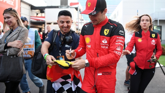 Ferrari's Monegasque driver Charles Leclerc signs autographs to fans after the qualifying session for the Formula One Azerbaijan Grand Prix at the Baku City Circuit in Baku on April 28, 2023. (Photo by NATALIA KOLESNIKOVA / AFP)