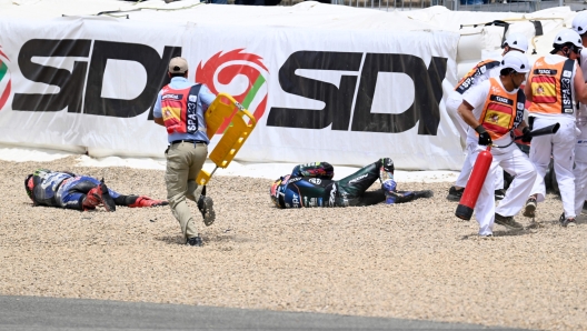 Rescuers tend to Yamaha French rider Fabio Quartararo (L) after falling during the MotoGP Spanish Grand Prix at the Jerez racetrack in Jerez de la Frontera on April 30, 2023. (Photo by JORGE GUERRERO / AFP)