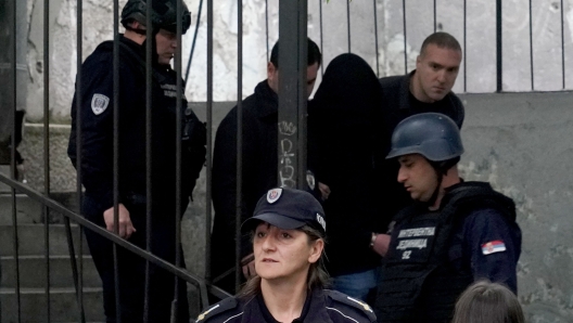 Police officers escort a minor, a seventh grade student who is suspected of firing several shots at a school in the capital Belgrade on May 3, 2023. - Serbian police arrested a student following a shooting at an elementary school in the capital Belgrade on May 3, 2023, the interior ministry said. The shooting occurred at 8:40 am local time (06:40 GMT) at an elementary school in Belgrade's downtown Vracar district. (Photo by Oliver Bunic / AFP) / Serbia OUT