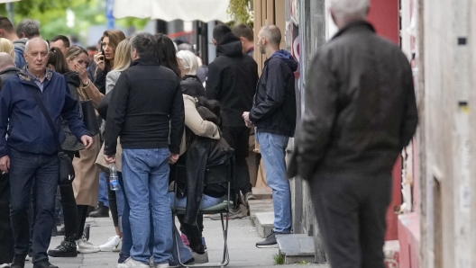 People wait in front of the Vladislav Ribnikar school after shooting in Belgrade, Serbia, Wednesday, May 3, 2023. A teenage boy opened fire early Wednesday in a school in central Belgrade, causing injuries. (AP Photo/Darko Vojinovic)