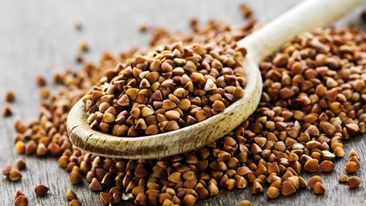 Buckwheat seeds on wooden spoon in closeup