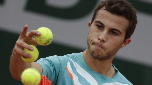 FILE - France's Hugo Gaston prepares to serve against Japan's Yoshihito Nishioka in the second round match of the French Open tennis tournament at the Roland Garros stadium in Paris, France, Wednesday, Sept. 30, 2020. On Monday, May 22, 2023, the ATP Tour announced Gaston was fined 144,000 euros (about $155,000) - more than he?s collected in prize money so far in 2023 - for pulling a ball out of his pocket and throwing it on the court during a point in an attempt to get a do-over, his fourth unsportsmanlike conduct violation this season. (AP Photo/Alessandra Tarantino, File)