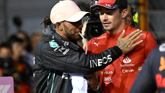 Mercedes' British driver Lewis Hamilton (L) greets Ferrari's Monegasque driver Charles Leclerc (R) after the qualifying session ahead of the Formula One Singapore Grand Prix night race at the Marina Bay Street Circuit in Singapore on October 1, 2022. (Photo by ROSLAN RAHMAN / AFP)