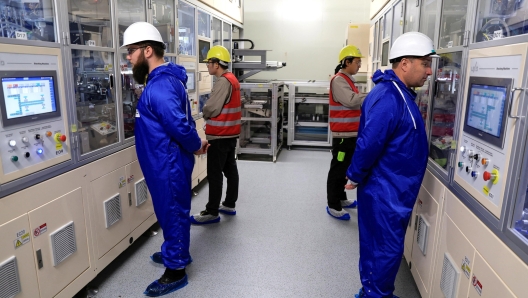 epa10662819 Employees stand next to equipment at the gigafactory of Automotive Cells Company (ACC), a joint venture of Stellantis, TotalEnergies and Mercedes, during its inauguration in Billy-Berclau-Douvrin, northern France, 30 May 2023.  EPA/PASCAL ROSSIGNOL / POOL  MAXPPP OUT