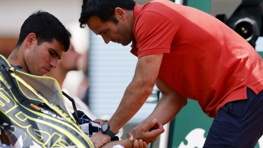 Spain's Carlos Alcaraz receives medical assistance during his semifinal match of the French Open tennis tournament against Serbia's Novak Djokovic at the Roland Garros stadium in Paris, Friday, June 9, 2023. (AP Photo/Jean-Francois Badias)