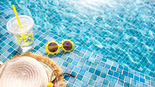 Summer vacation concept. Stylish yellow sunglasses, hat and fresh cocktail. Flat lay. Space for text. Time to travel