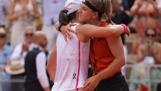 Poland's Iga Swiatek (L) comforts Czech Republic's Karolina Muchova after her victory during their women's singles final match on day fourteen of the Roland-Garros Open tennis tournament at the Court Philippe-Chatrier in Paris on June 10, 2023. (Photo by Thomas SAMSON / AFP)