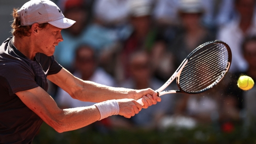 Italy's Jannik Sinner plays a backhand return to Germany's Daniel Altmaier during their men's singles match on day five of the Roland-Garros Open tennis tournament at the Court Suzanne-Lenglen in Paris on June 1, 2023. (Photo by Anne-Christine POUJOULAT / AFP)