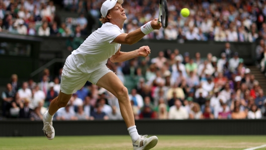 LONDON, ENGLAND - JULY 05: Jannik Sinner of Italy plays a forehand against Novak Djokovic of Serbia during their Men's Singles Quarter Final match on day nine of The Championships Wimbledon 2022 at All England Lawn Tennis and Croquet Club on July 05, 2022 in London, England. (Photo by Julian Finney/Getty Images)