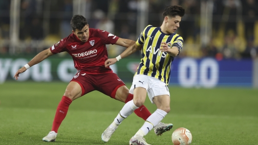 Sevilla's Marcos Acuna, left, challenges for the ball with Fenerbahce's Arda Guler during the Europa League round of 16 second leg soccer match between Fenerbahce and Sevilla at Sukru Saracoglu stadium in Istanbul, Turkey, Thursday, March 16, 2023. (AP Photo)