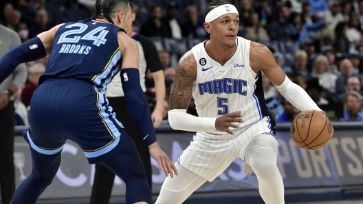 Orlando Magic forward Paolo Banchero (5) handles the ball against Memphis Grizzlies forward Dillon Brooks (24) in the first half of an NBA basketball game Tuesday, March 28, 2023, in Memphis, Tenn. (AP Photo/Brandon Dill)