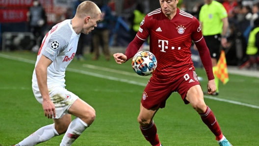 Salzburg's Danish defender Rasmus Kristensen (L) and Bayern Munich's Polish forward Robert Lewandowski vie for the ball during the UEFA Champions League last-16, first-leg football match RB Salzburg v FC Bayern Munich in Salzburg, Austria on February 16, 2022. (Photo by BARBARA GINDL / APA / AFP) / Austria OUT