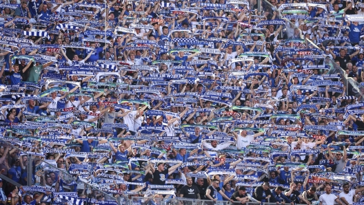 Schalke fans hold show their team scarves after the German Bundesliga soccer match between RB Leipzig and FC Schalke 04 in Leipzig, Germany, Saturday, May 27, 2023. FC Schalke 04 is relegated to the second Bundesliga after losing 4:2 to Leipzig. ( Jan Woitas/dpa via AP)