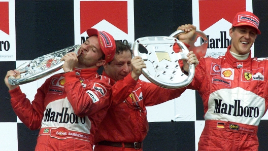 20020818 - BUDAPEST, HUNGARY- SPR -FORMULA 1: DOPPIETTA FERRARI : Brazilian Ferrari driver Rubens Barichello (L), Ferrari team chef Jean Todt (C) and German teammate Michael Schumacher celebrate with their trophy's on the podium of the Hungarian Formula One Grand Prix at the Hungaroring in Budapest, Sunday 18 August 2002. Barrichello won ahead of second placed Schumacher.                      ANSA / ATTILA KISBENEDEK / CD