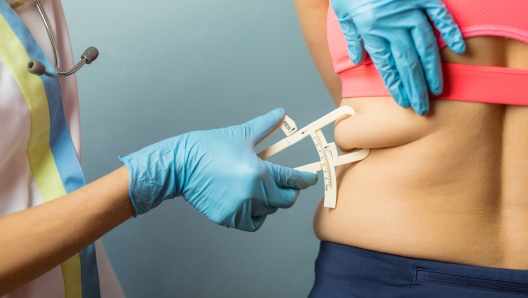 Doctor using body fat caliper