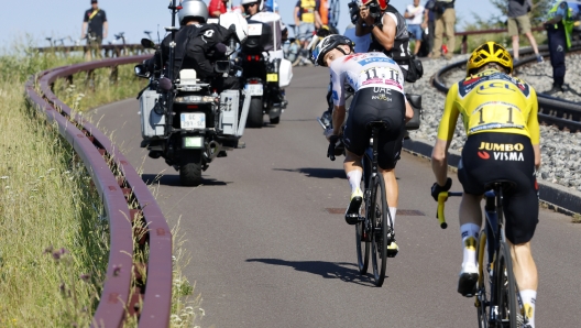 Slovenia's Tadej Pogacar, wearing the best young rider's white jersey, looks back at Denmark's Jonas Vingegaard, wearing the overall leader's yellow jersey, on the climb to Puy de Dome during the ninth stage of the Tour de France cycling race over 182.5 kilometers (113.5 miles) with start in Saint-Leonard-de-Noblat and finish in Puy de Dome, France, Sunday, July 9, 2023. (Etienne Garnier, Pool via AP)