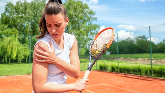 Pretty young girl injured during tennis practice, sport injuries