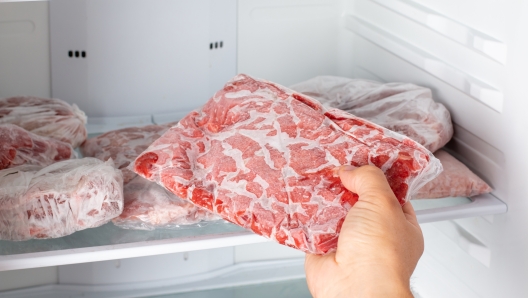 Man taking out frozen meat from freezer. Frozen food