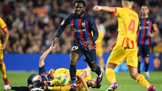 Barcelona's Ivorian midfielder Franck Kessie (C) is challenged by Girona's Spanish defender Arnau Martinez during the Spanish league football match between FC Barcelona and Girona FC at the Camp Nou stadium in Barcelona on April 10, 2023. (Photo by Pau BARRENA / AFP)