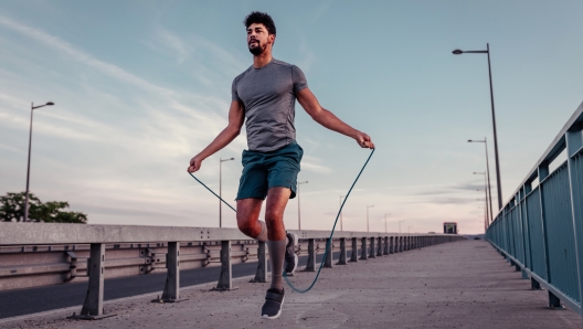 Young man jumping rope outside