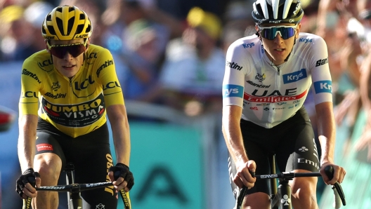 Jumbo-Visma's Danish rider Jonas Vingegaard wearing the overall leader's yellow jersey (L) and UAE Team Emirates' Slovenian rider Tadej Pogacar wearing the best young rider's white jersey cycle to the finish line of the 15th stage of the 110th edition of the Tour de France cycling race, 179 km between Les Gets Les Portes du Soleil and Saint-Gervais Mont-Blanc, in the French Alps, on July 16, 2023. (Photo by Thomas SAMSON / AFP)