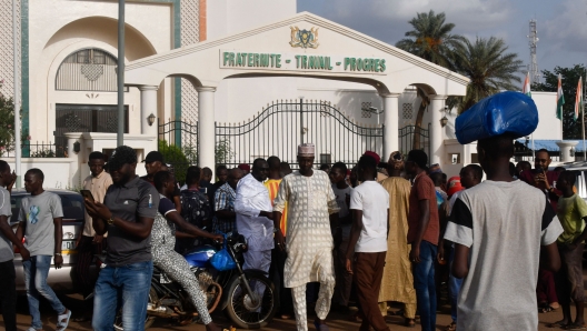 TOPSHOT - Demosnstrators gather to protest the detention of President Mohamed Bazoum by the Presidential Guard in Niamey on July 26, 2023. Niger's Presidential Guard on July 26, 2023 fired warning shots to disperse demonstrators protesting over the detention of President Mohamed Bazoum by members of the elite unit, an AFP journalist saw.  Bazoum supporters tried to approach the presidential complex where the head of state is being held by Presidential Guards, but scattered when the shots were fired. (Photo by AFP)