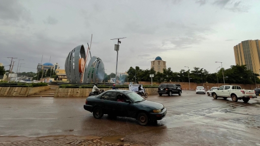 Vehicles drive at a roundabout in Niamey on July 27, 2023 after Niger's President Mohamed Bazoum was detained by elite troops who declared they had taken power in the troubled West African nation. Bazoum was confined in Niamey on July 26, 2023 by members of his presidential guard, who hours later announced that "all institutions" in the country would be suspended, the borders closed and a night-time curfew imposed. (Photo by AFP)