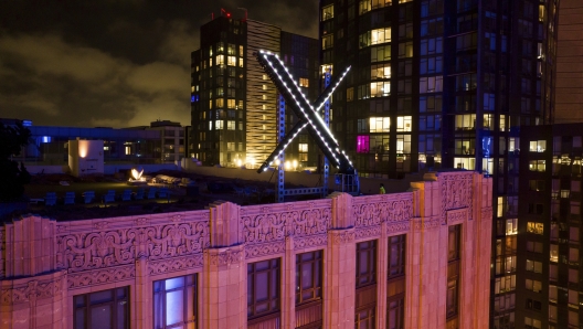 Workers install lighting on an "X" sign atop the company headquarters, formerly known as Twitter, in downtown San Francisco, on Friday, July 28, 2023. San Francisco has launched an investigation into the sign as city officials say replacing letters or symbols on buildings, or erecting a sign on top of one, requires a permit. (AP Photo/Noah Berger)