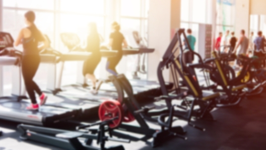 Blurred photo of a gym with people on treadmills