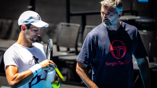 World Number 5 ranked player Novak Djokovic (L) listens to his coach Goran Ivanisevic (R) during a practice match with Russian player Daniil Medvedev ahead of the Australian Open tennis tournament in  Melbourne Park on January 11, 2023. (Photo by Patrick HAMILTON / AFP) / -- IMAGE RESTRICTED TO EDITORIAL USE - STRICTLY NO COMMERCIAL USE --