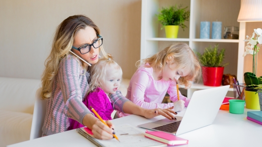 Busy woman trying to work while babysitting two kids