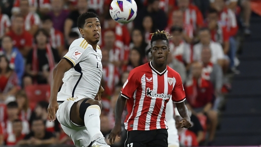 Real Madrid's Jude Bellingham, left, and Athletic Bilbao's Nico Williams challenge for the ball during the Spanish La Liga soccer match between Athletic Club and Real Madrid at the San Mames stadium in Bilbao, Spain, Saturday, Aug. 12, 2023. (AP Photo/Alvaro Barrientos)