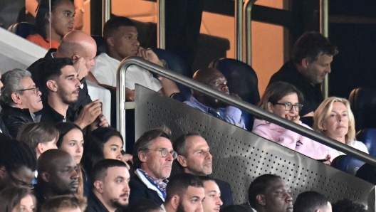 Paris Saint-Germain's French forward Kylian Mbappe attends from the stand the French L1 football match between Paris Saint-Germain (PSG) and Lorient at the Parc des Princes Stadium in Paris on August 12, 2023. (Photo by Miguel MEDINA / AFP)