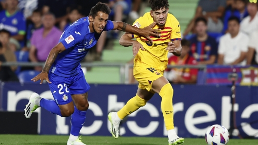 Barcelona's Abde Ezzalzouli, right, and Getafe's Damian Suarez challenge for the ball during the Spanish La Liga soccer match between Getafe and FC Barcelona at the Coliseum Alfonso Perez stadium in Getafe, Spain, Sunday, Aug. 13, 2023. (AP Photo/Alvaro Medranda)