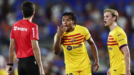 Barcelona's Jules Kounde, centre, and Barcelona's Frenkie de Jong appeal to the linesman during the Spanish La Liga soccer match between Getafe and FC Barcelona at the Coliseum Alfonso Perez stadium in Getafe, Spain, Sunday, Aug. 13, 2023. (AP Photo/Alvaro Medranda)