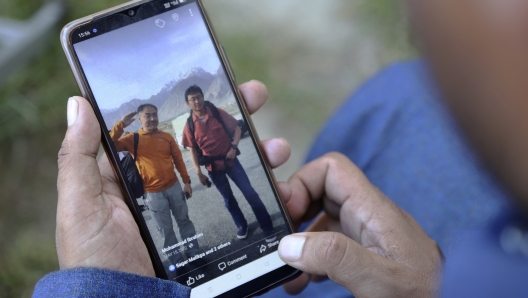 Pakistani guide Muhammad Ibrahim shows a picture of Japanese climbers, Semba Takayasu with Shinji Tamura, who was died during summiting highest and unscaled peaks, in his mobile, in Skardu, Pakistan, Tuesday, Aug. 15, 2023. Japanese climber Shinji Tamura died, and his fellow mountaineer Semba Takayasu was injured while trying to scale one of the highest and unscaled peaks in northern Pakistan last week, a mountaineering official and the injured climber said on Tuesday. (AP Photo/M.H. Balti)