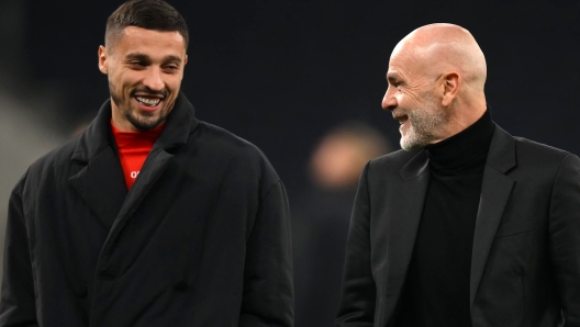 AC Milan's Bosnian midfielder Rade Krunic (L) talks with AC Milan's Italian coach Stefano Pioli as they walk on the pitch at Tottenham Hotspur Stadium in London, on March 7, 2023, on the eve of their UEFA Champions League round of 16 second-leg football match against AC Milan. (Photo by Daniel LEAL / AFP)