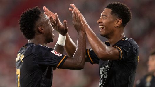 Real Madrid's Brazilian forward #07 Vinicius Junior (L) celebrates scoring his team's third goal, with Real Madrid's English midfielder #5 Jude Bellingham, during the Spanish Liga football match between UD Almeria and Real Madrid CF at the Municipal Stadium of the Mediterranean Games in Almeria on August 19, 2023. (Photo by JORGE GUERRERO / AFP)