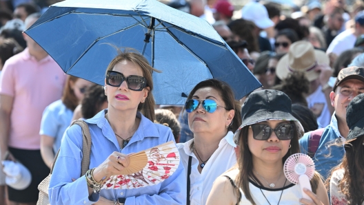 Turisti e fedeli nella morsa del caldo in attesa dellAngelus di Papa Francesco, 20 August 2023. ANSA/CLAUDIO PERI