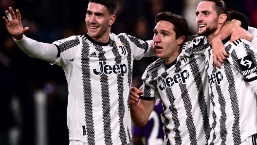 Juventus' French midfielder Adrien Rabiot (R) celebrates with Juventus' Serbian forward Dusan Vlahovic (L) and Juventus' Italian forward Federico Chiesa after opening the scoring during the Italian Serie A football match between Juventus and Fiorentina on February 12, 2023 at the Juventus stadium in Turin. (Photo by Marco BERTORELLO / AFP)