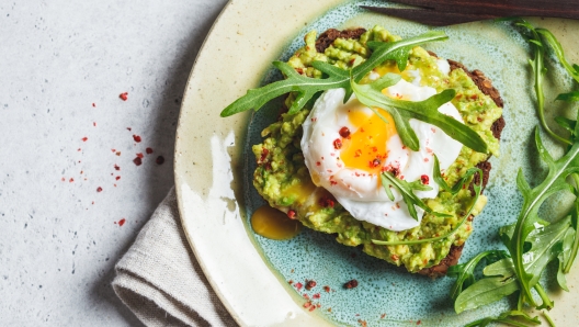 Avocado and poached egg toast on rye bread. Healthy breakfast concept.