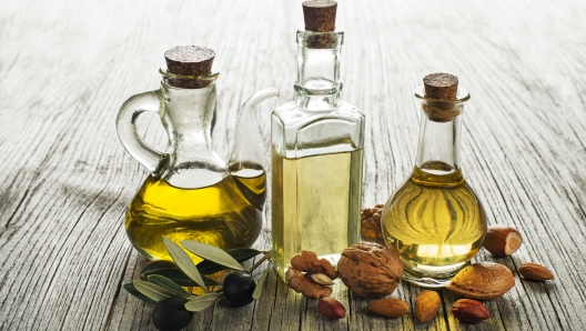 Olive, walnut and almond oil on wooden background